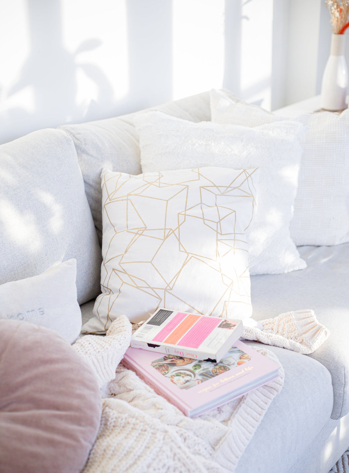 Cozy couch with a blanket and books